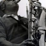 a man playing Saxophone and looking upward