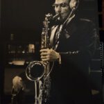 a man with headphone is playing a Saxophone