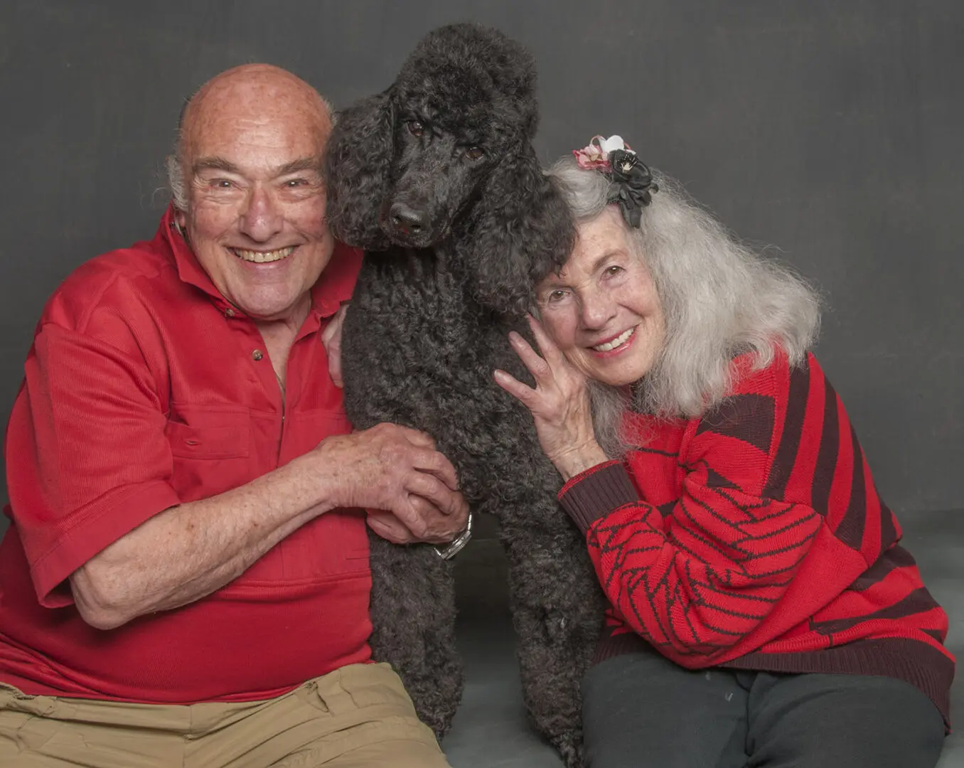 an elderly couple with a black color dog